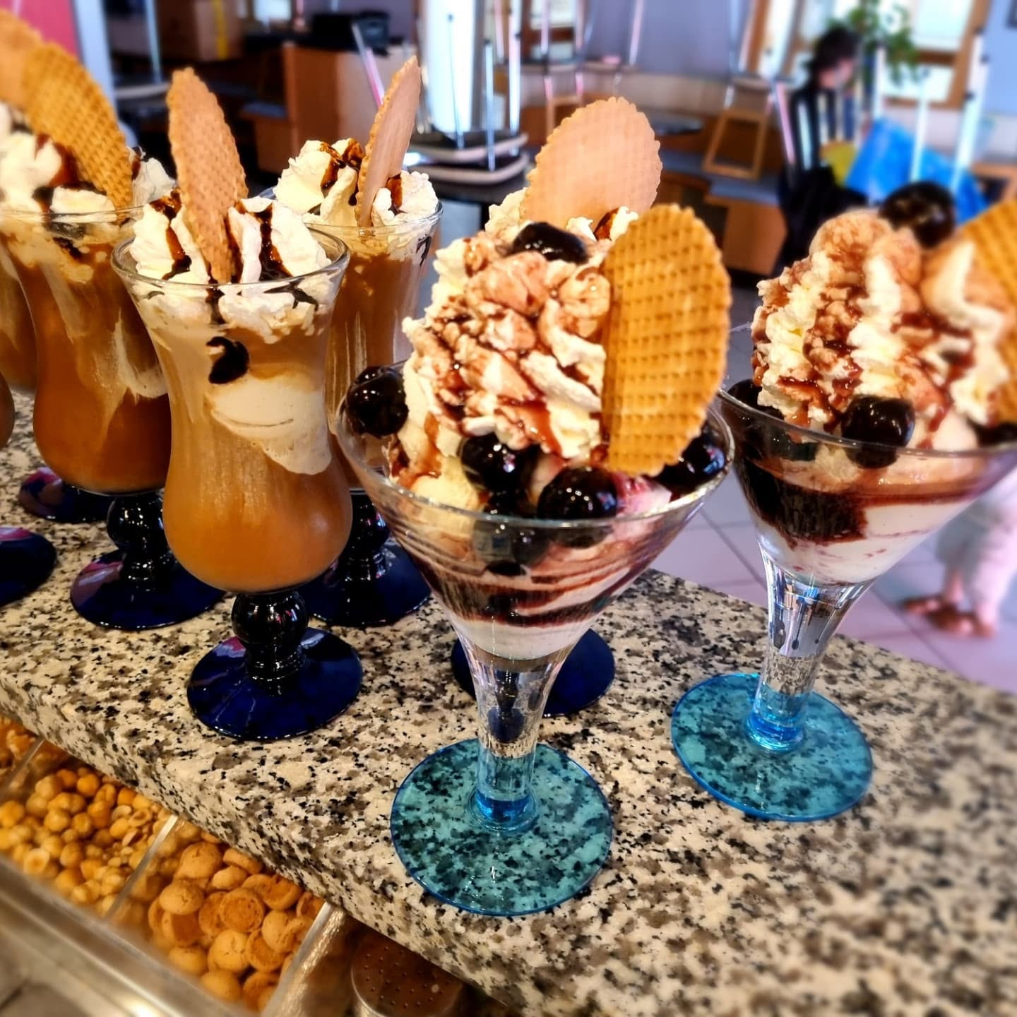 Mehrere Eisbecher und Eiskaffee-Gläser an der Theke