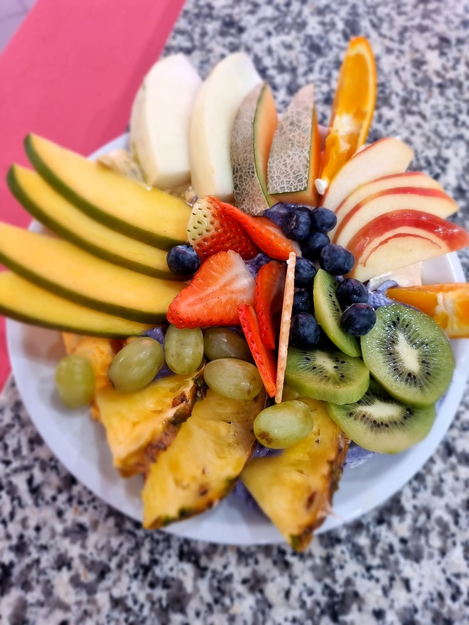 Frischer Obstteller mit Erdbeeren, Kiwi, Ananas und Melone