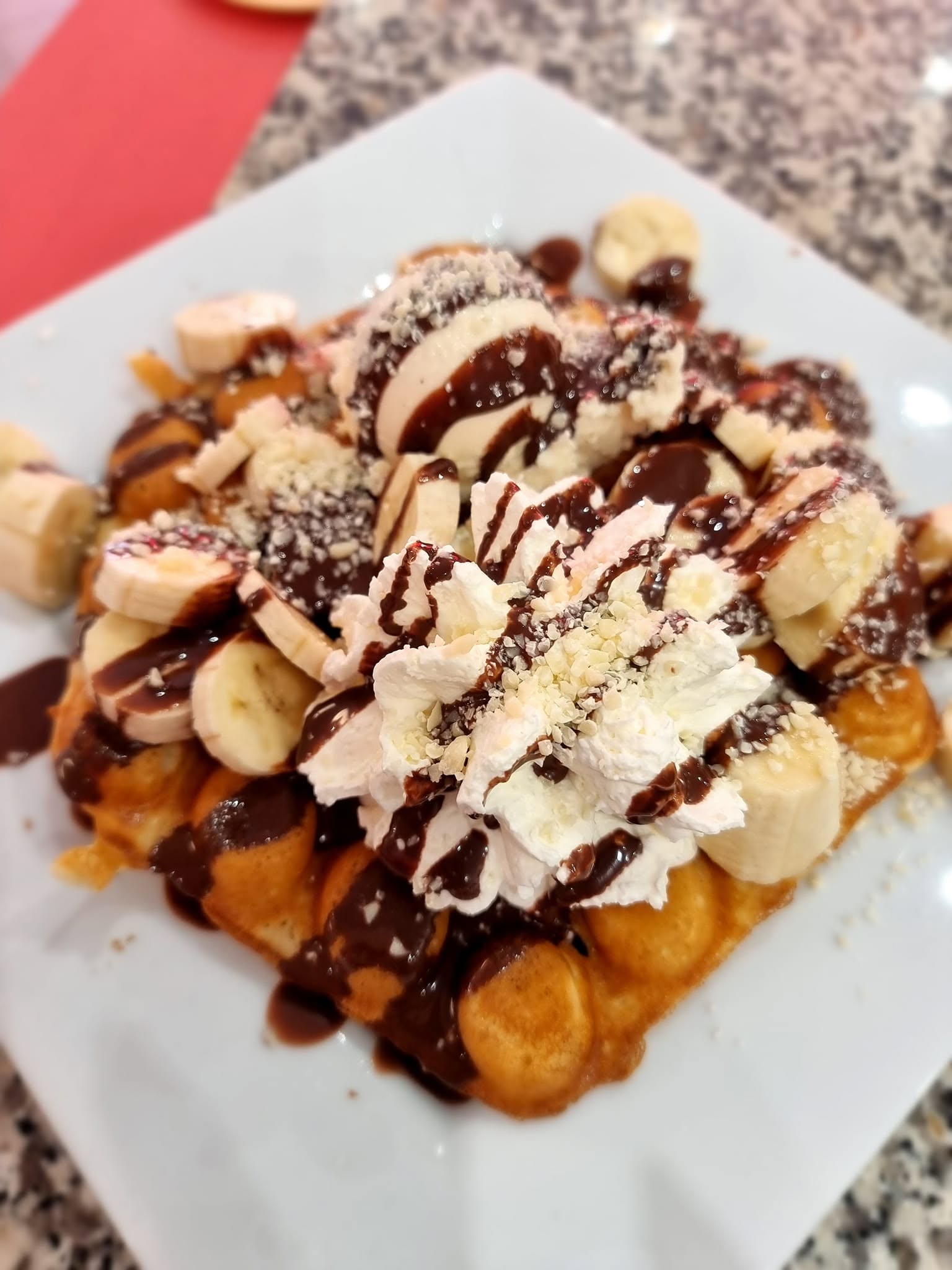 Waffel-Dessert mit Banane, Sahne und Schokoladensauce